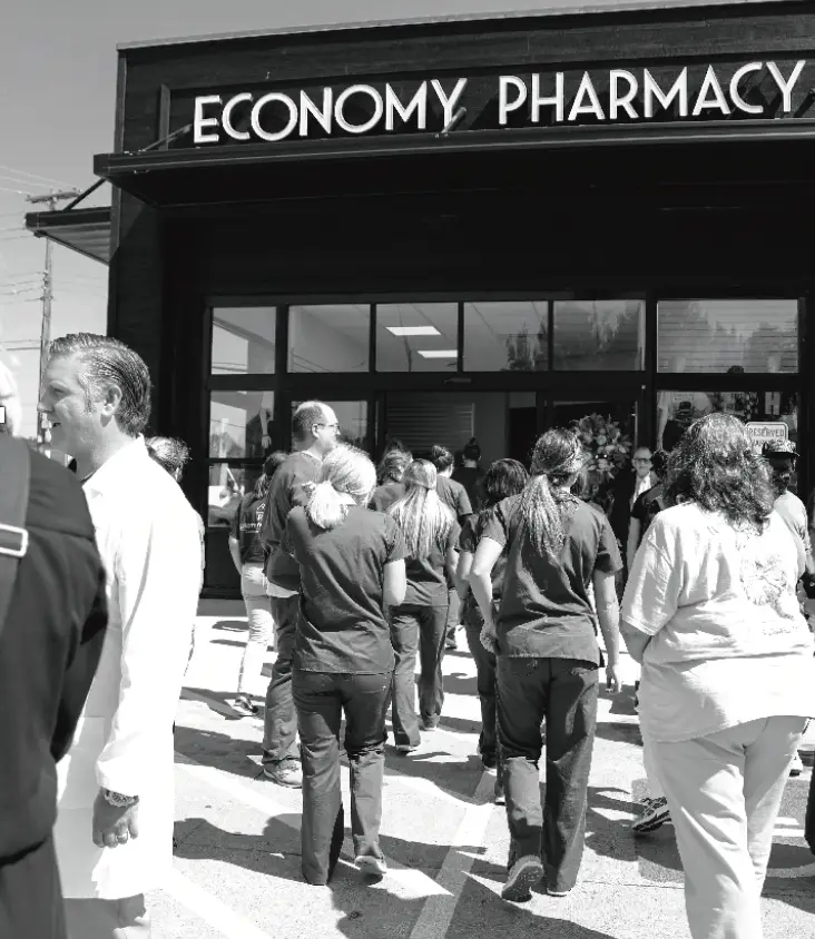 Economy Pharmacy team members walking to the store entrance